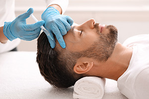 Middle-aged man having hair treatment